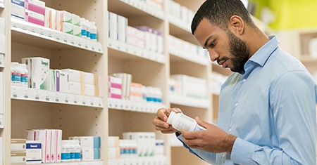 man reading pill bottle